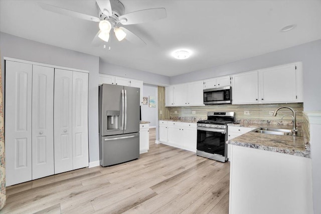 kitchen featuring white cabinetry, sink, light wood-type flooring, and appliances with stainless steel finishes