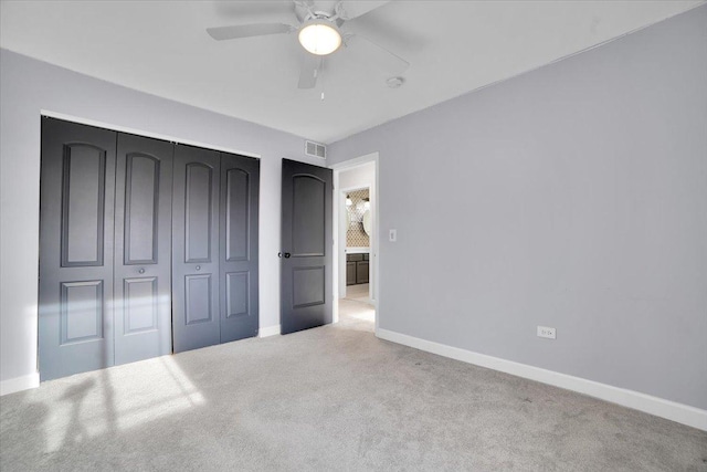 unfurnished bedroom featuring a closet, light colored carpet, and ceiling fan