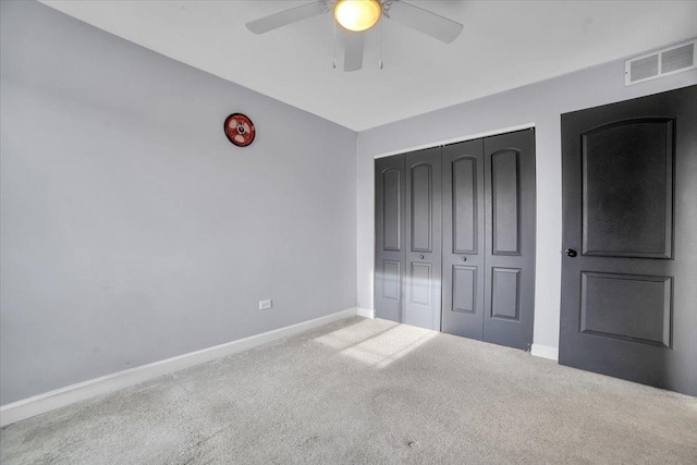 unfurnished bedroom with ceiling fan, a closet, and carpet floors