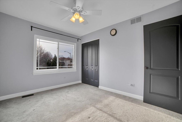 unfurnished bedroom with ceiling fan, light colored carpet, and a closet