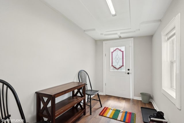 foyer entrance featuring baseboards and wood finished floors