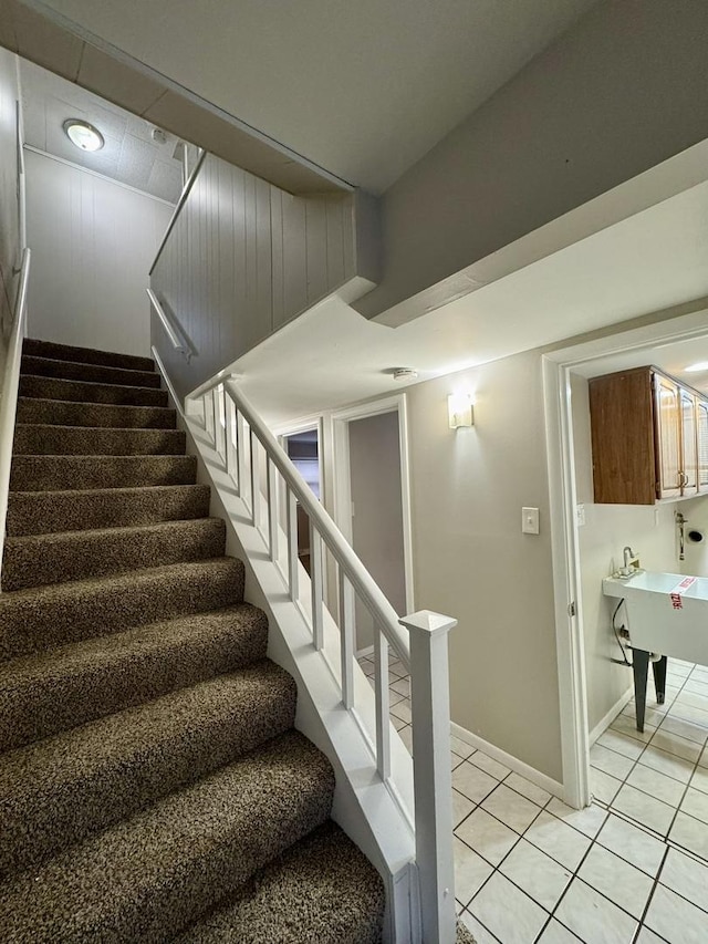 staircase featuring tile patterned flooring and sink