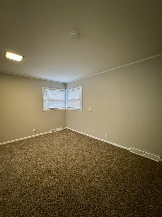 unfurnished room with carpet flooring and crown molding