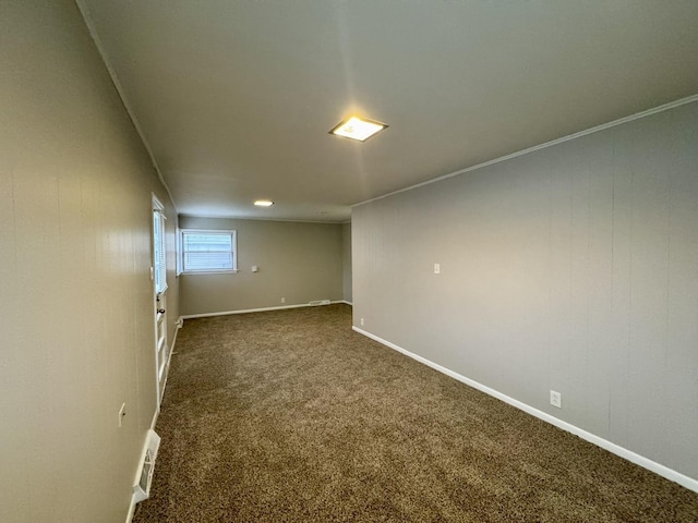 unfurnished room with dark colored carpet and crown molding