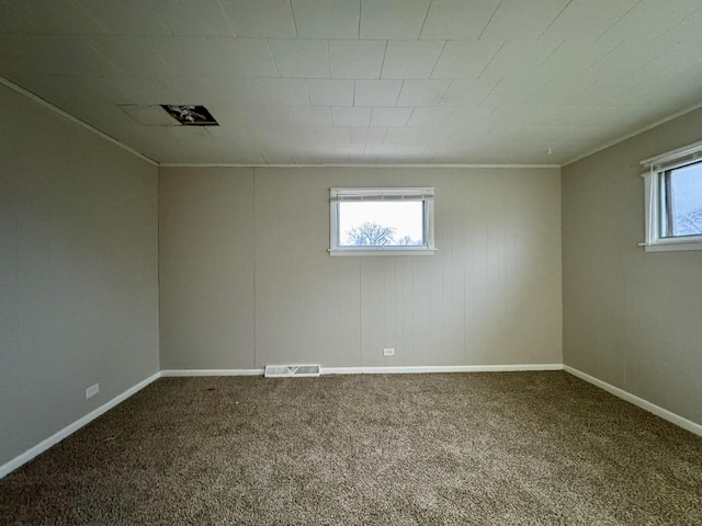 spare room featuring crown molding, plenty of natural light, and carpet floors