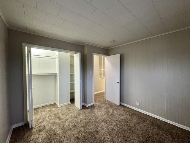 unfurnished bedroom with a closet, carpet floors, and ornamental molding