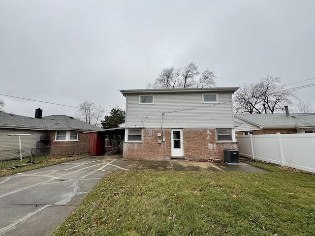 back of property featuring a lawn, central AC, and a carport