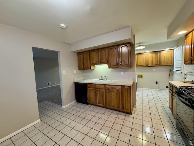 kitchen featuring black appliances, light tile patterned flooring, and sink