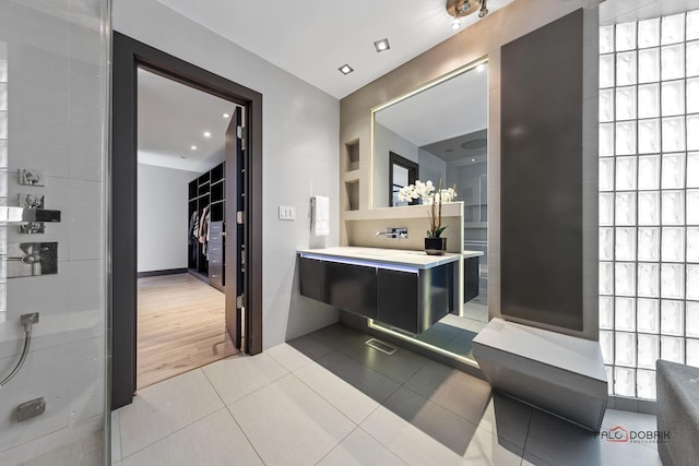 bathroom with wood-type flooring, vanity, and walk in shower