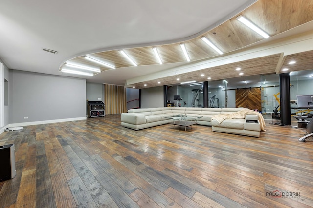 living room featuring wood-type flooring, a barn door, and wooden ceiling