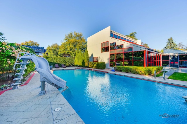 view of pool with a patio and a water slide