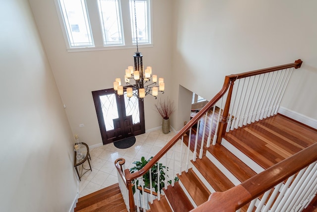 entryway with light hardwood / wood-style floors, a healthy amount of sunlight, french doors, and a chandelier