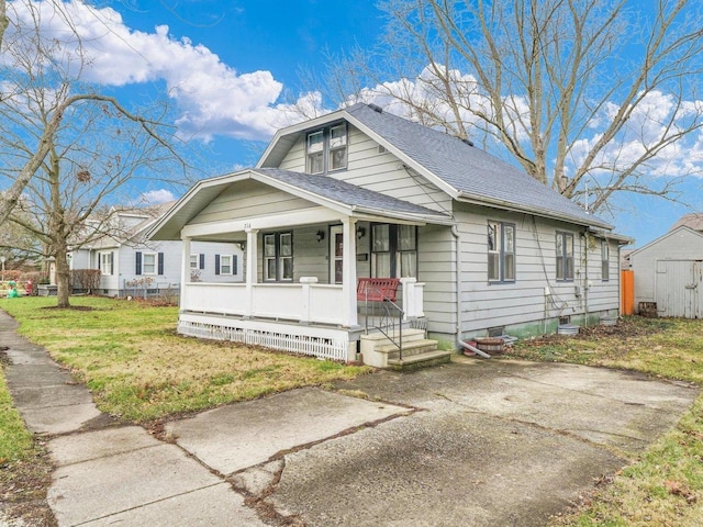 bungalow-style home with covered porch and a front yard