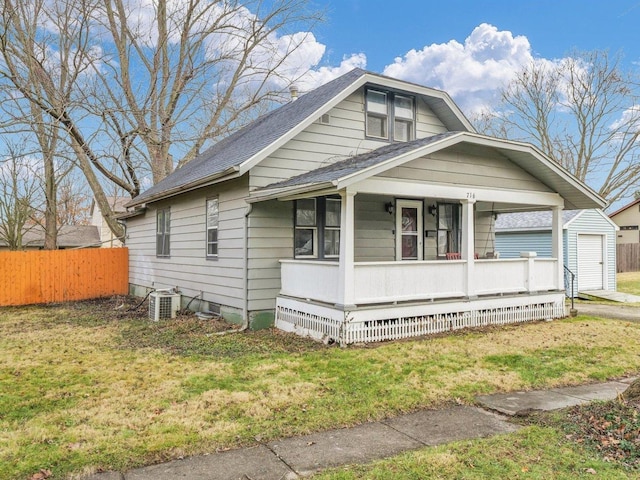 bungalow-style home featuring central air condition unit, a front lawn, and covered porch