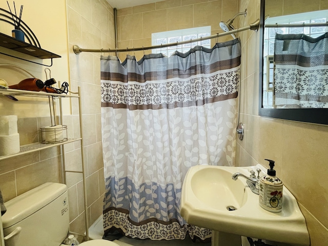 bathroom featuring plenty of natural light, tile walls, and curtained shower