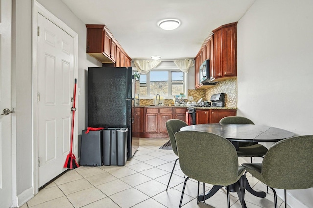 kitchen with decorative backsplash, sink, light tile patterned floors, and stainless steel appliances