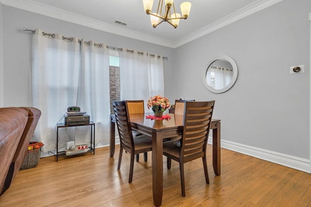 dining space with an inviting chandelier, light hardwood / wood-style flooring, and ornamental molding