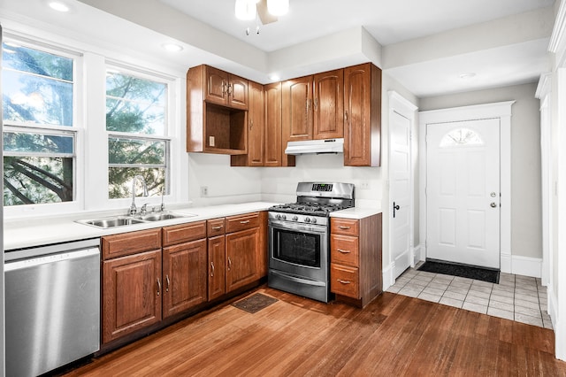 kitchen with ceiling fan, sink, stainless steel appliances, and wood-type flooring