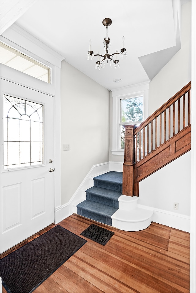 entrance foyer featuring hardwood / wood-style floors and a chandelier