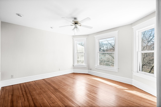 unfurnished room featuring ceiling fan, a healthy amount of sunlight, and wood-type flooring