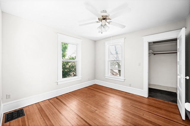 unfurnished bedroom with ceiling fan, a closet, and hardwood / wood-style flooring