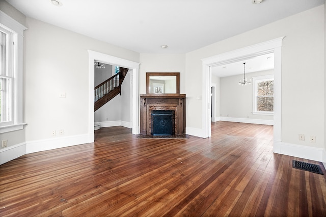 unfurnished living room featuring hardwood / wood-style flooring and an inviting chandelier