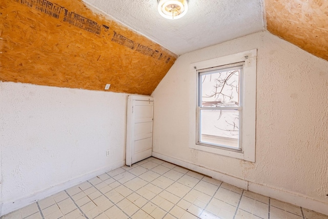 bonus room featuring lofted ceiling and a textured ceiling