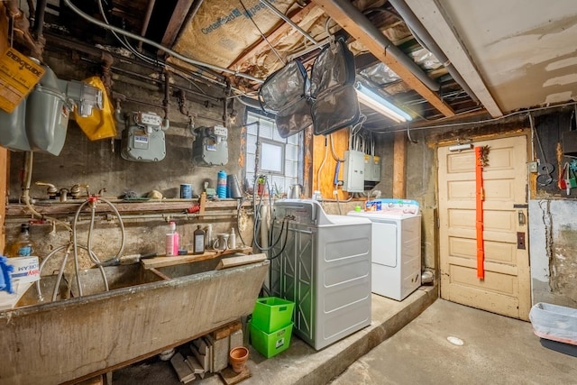 basement with washing machine and clothes dryer, electric panel, and sink