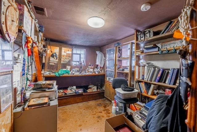 miscellaneous room featuring a workshop area and a textured ceiling