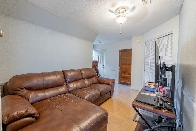 living room featuring a textured ceiling and ceiling fan