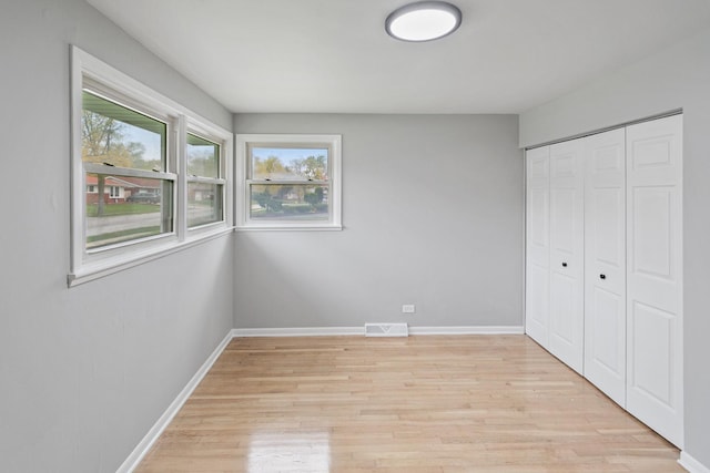 unfurnished bedroom featuring light hardwood / wood-style floors and a closet