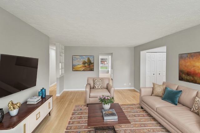 living room with light hardwood / wood-style floors and a textured ceiling