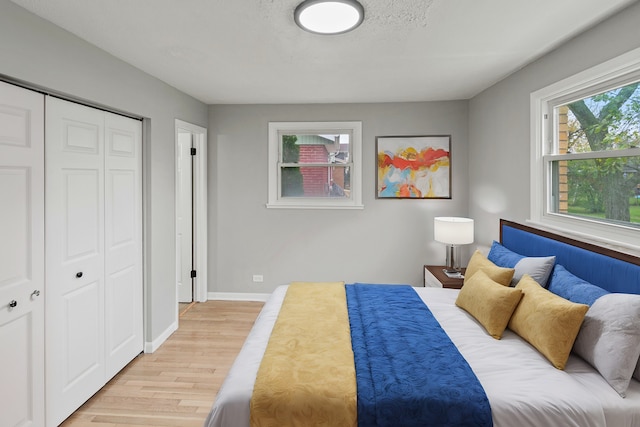 bedroom featuring a closet, a textured ceiling, and light wood-type flooring