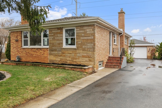 view of side of home featuring a yard, a garage, and an outdoor structure