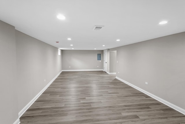 unfurnished room featuring electric panel and dark hardwood / wood-style flooring