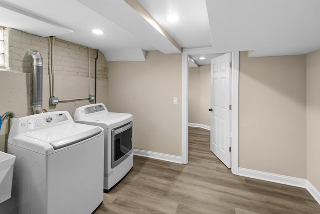 laundry room featuring washer and clothes dryer and light hardwood / wood-style flooring