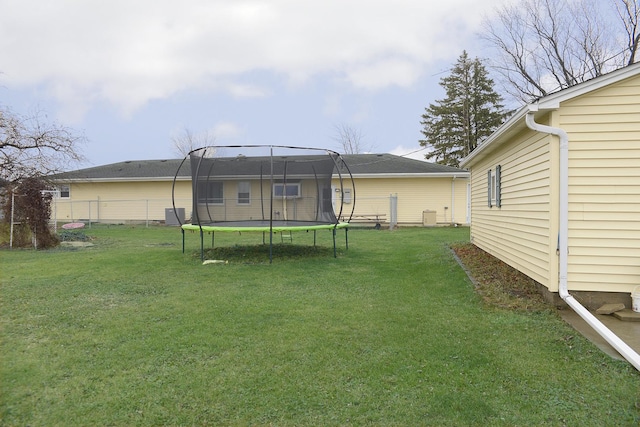 view of yard with central AC unit and a trampoline