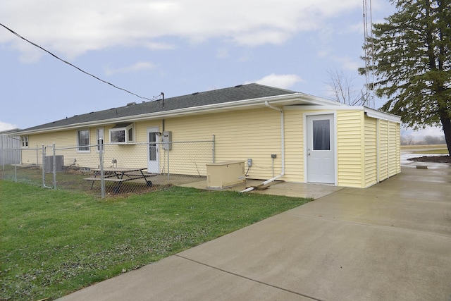 rear view of house featuring a lawn and central air condition unit