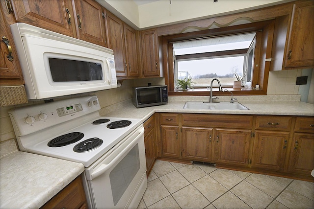 kitchen with white appliances, sink, light tile patterned floors, and tasteful backsplash