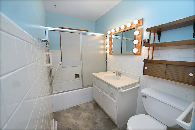 full bathroom featuring vanity, tile patterned floors, toilet, enclosed tub / shower combo, and tile walls