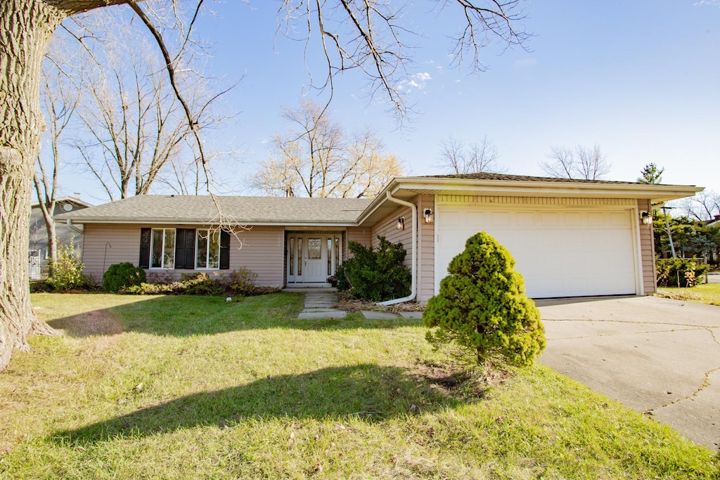 single story home featuring a front lawn and a garage