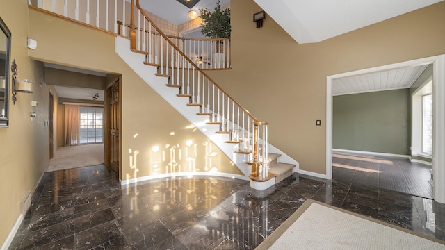 2239 Pine Bluff Dr, Dixon, IL 61021 - stairs featuring baseboards, marble tiled floors, and a towering ceiling