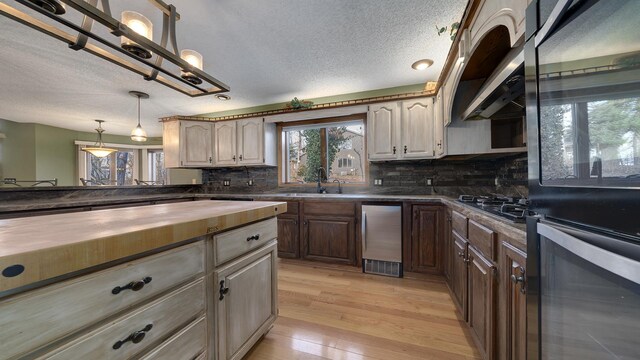 2239 Pine Bluff Dr, Dixon, IL 61021 - kitchen with wood counters, a sink, a textured ceiling, multiple ovens, and decorative backsplash