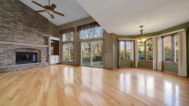2239 Pine Bluff Dr, Dixon, IL 61021 - unfurnished living room featuring high vaulted ceiling, ceiling fan, hardwood / wood-style flooring, healthy amount of natural light, and a textured ceiling