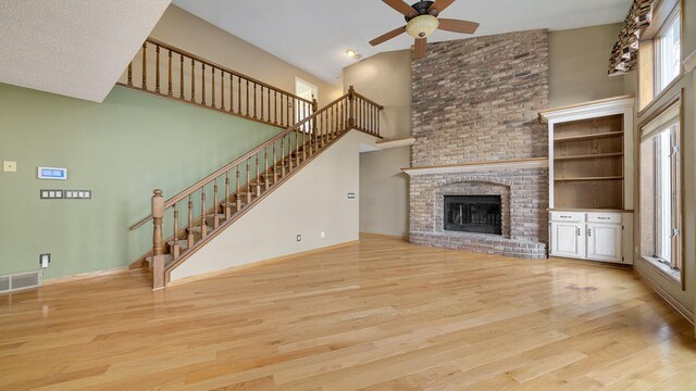 2239 Pine Bluff Dr, Dixon, IL 61021 - unfurnished living room with a towering ceiling, a ceiling fan, wood finished floors, healthy amount of natural light, and stairway