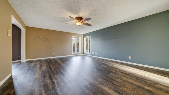 empty room with ceiling fan, dark hardwood / wood-style flooring, and a textured ceiling