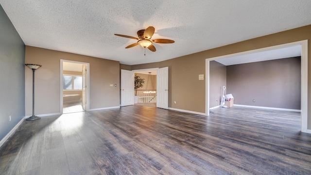spare room featuring dark hardwood / wood-style floors, ceiling fan, and a textured ceiling