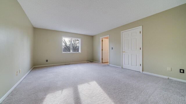 2239 Pine Bluff Dr, Dixon, IL 61021 - empty room featuring a textured ceiling, carpet, and baseboards