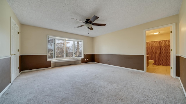 unfurnished room with ceiling fan, light colored carpet, and a textured ceiling