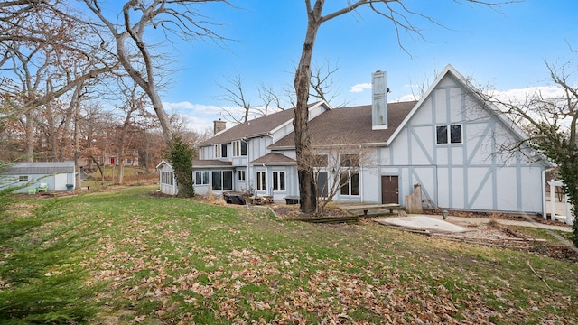 back of house with a lawn, a sunroom, and a storage shed